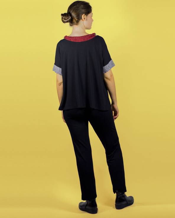 Blusa negra de manga corta con aplicaciones de colores. Conjunto pantalón estrecho de crepe.